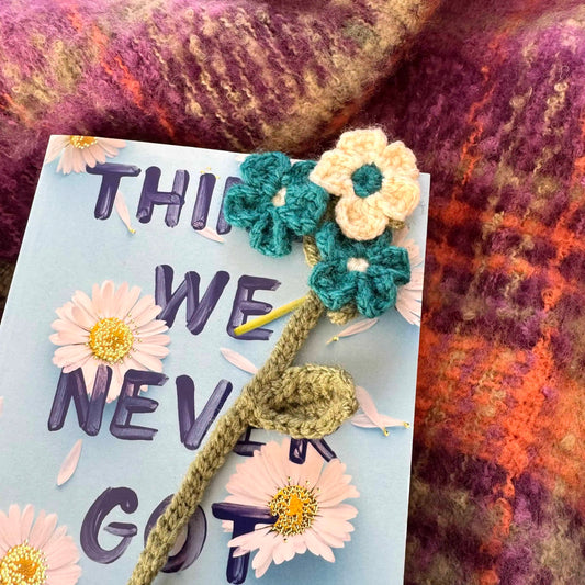 Crocheted flower bookmark against a textured fabric background.
