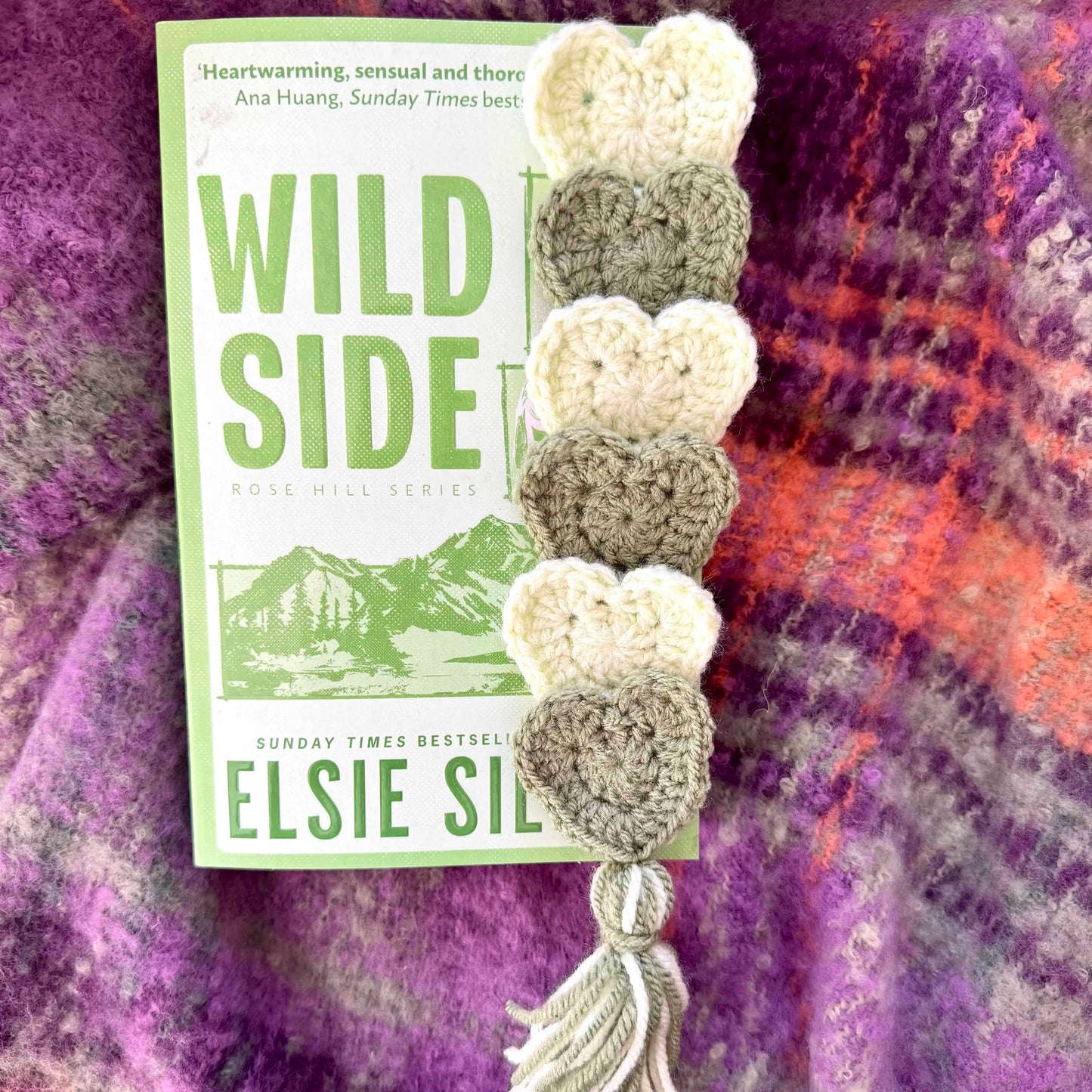 Crocheted heart bookmark on a textured fabric background