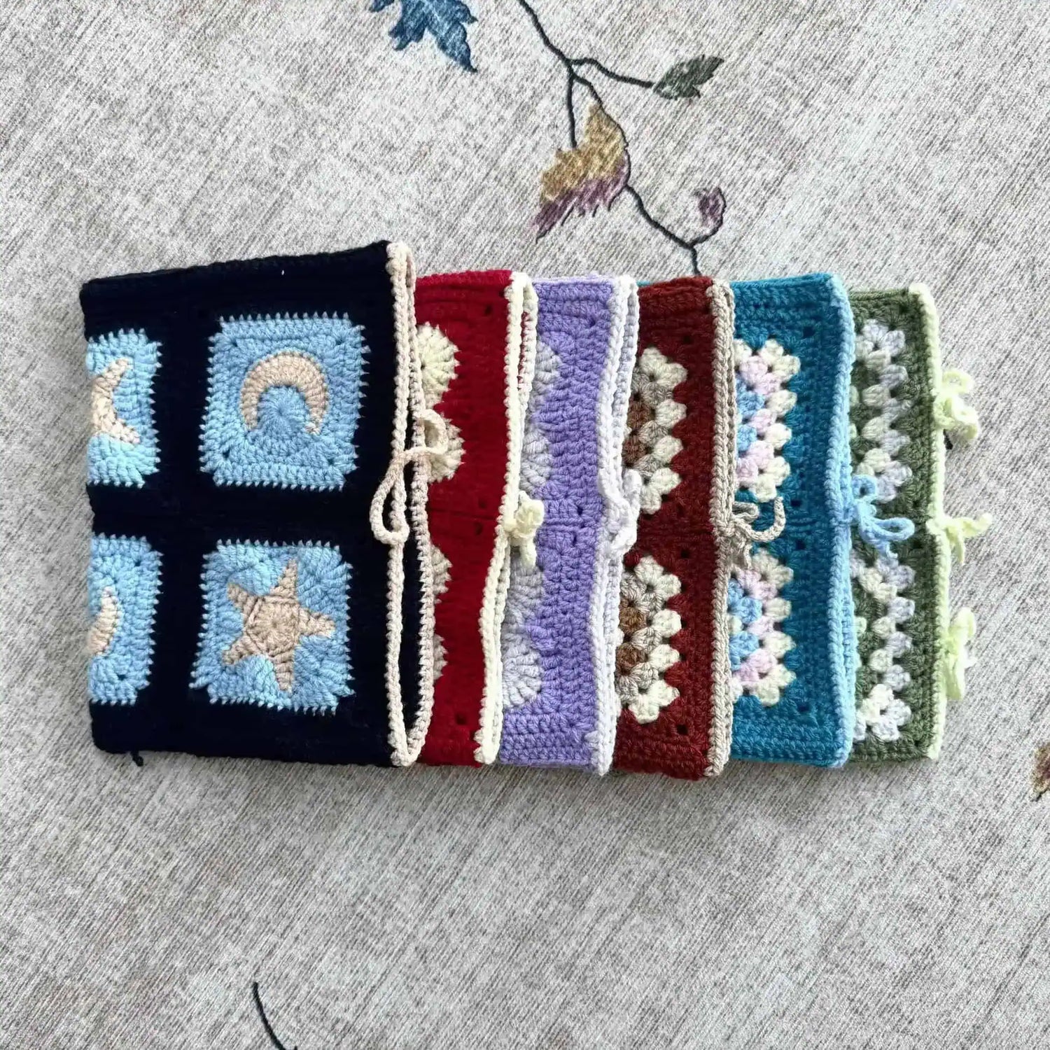Colourful crocheted book covers with geometric patterns.