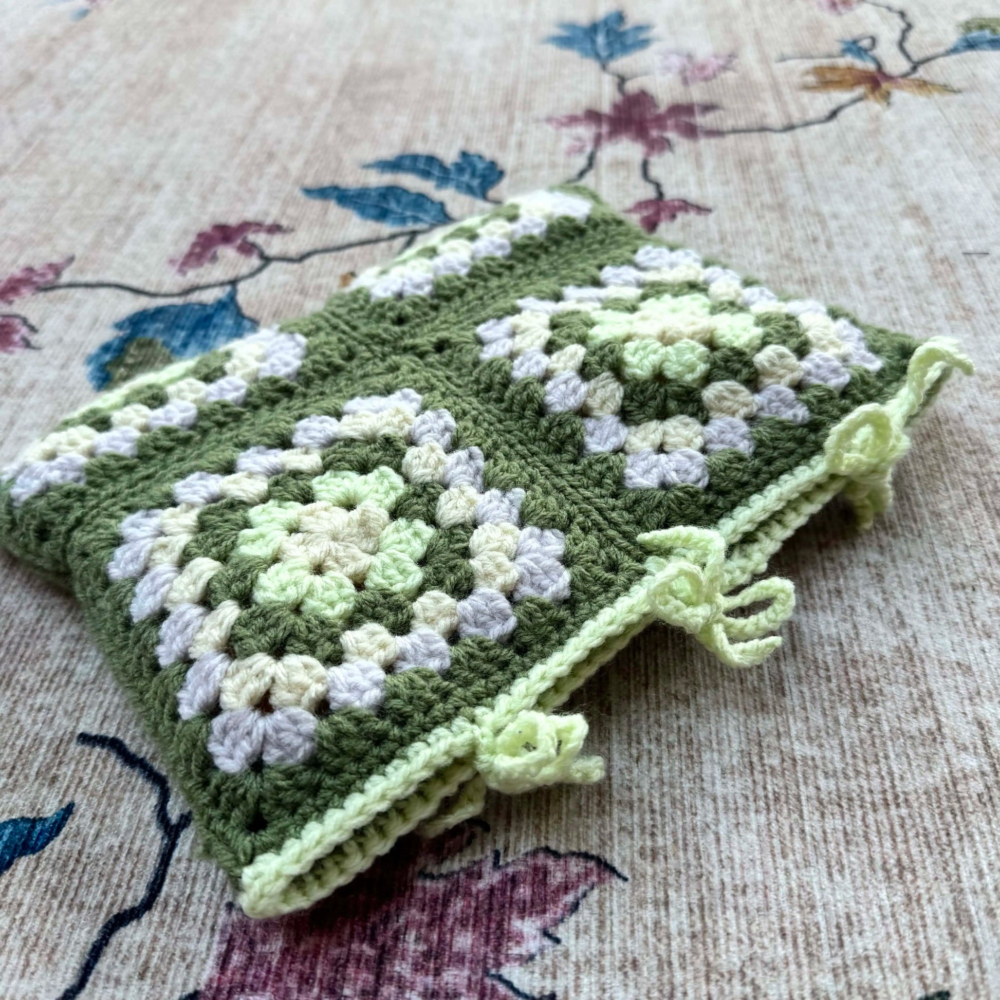 Green and white book cover on a floral-patterned fabric background